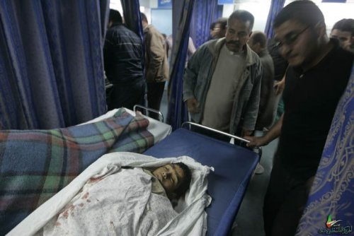 Dans un hôpital bondé, des hommes regardent, l'air abasourdi, un enfant palestinien mort sur un lit.